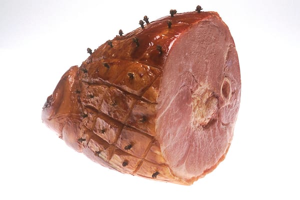 Photo of a whole baked ham, sliced to show the interior
