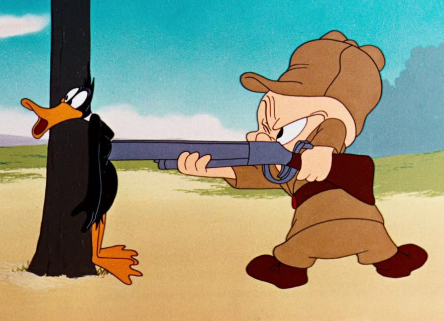 Portion of a cartoon cel depicting Daffy Duck standing against a tree with Elmer Fudd pointing a shotgun at his chest