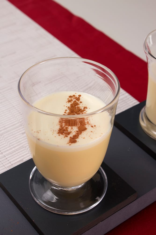 A glass of eggnog with cinnamon sprinkled on top