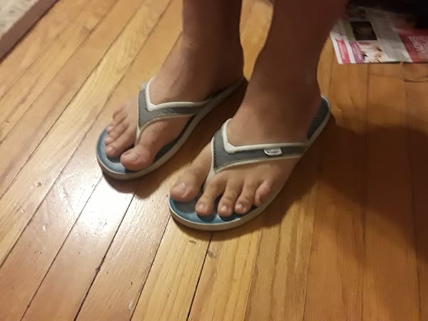 Photo of a pair of feet wearing flip-flop sandals