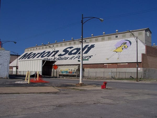 An industrial building with “Morton Salt: When it Rains it Pours” and the Morton Salt logo painted on the roof