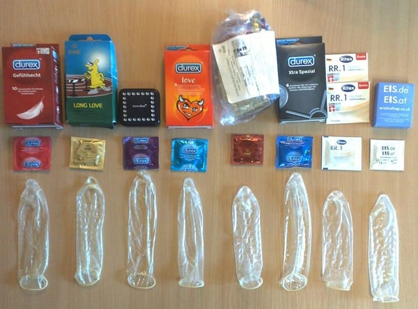 Display of eight unfurled condoms of different brands and their packaging