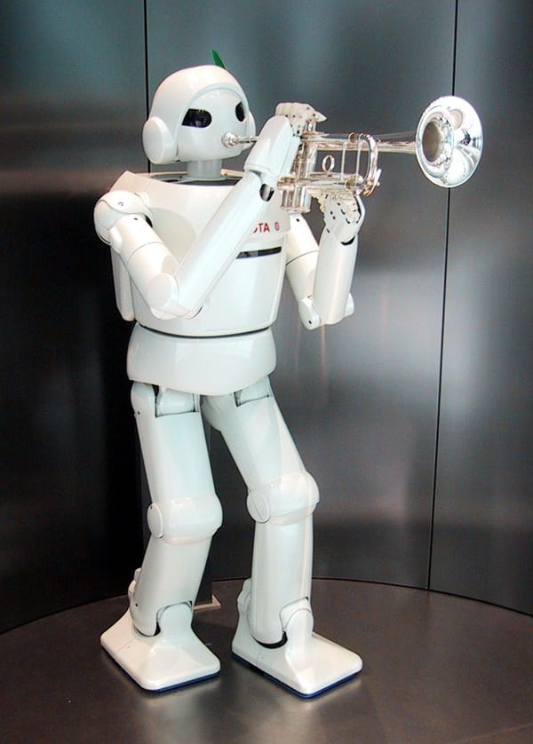 Photo of a human-shaped robot with a Toyota logo playing the trumpet