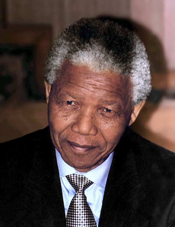 Headshot of South African President Nelson Mandela, a gray-haired, Black man in a suit and tie