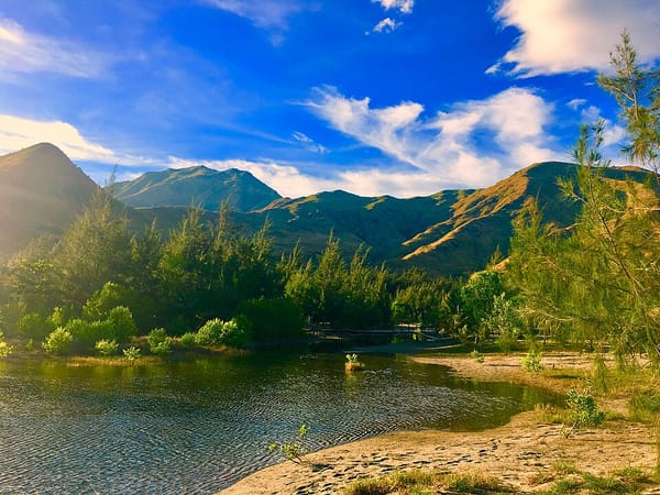 Photo of an isolated cove with mountains in the background
