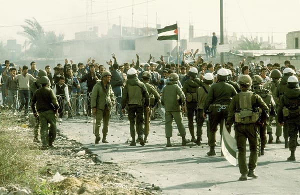 Photo of Israeli police and military confronting Palestinian protesters across a barbed-wire barrier